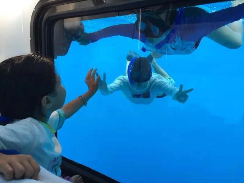 Slide: The Image of Child inside Penguin Semi-Submarine 2.1, interacting with snorkeler through window, 2025 model. - 17