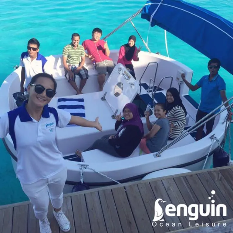 Slide: The Image of Group enjoying a ride on a 2025 Penguin Semi-Submarine 2.1 Gasoline in clear blue waters. - 8