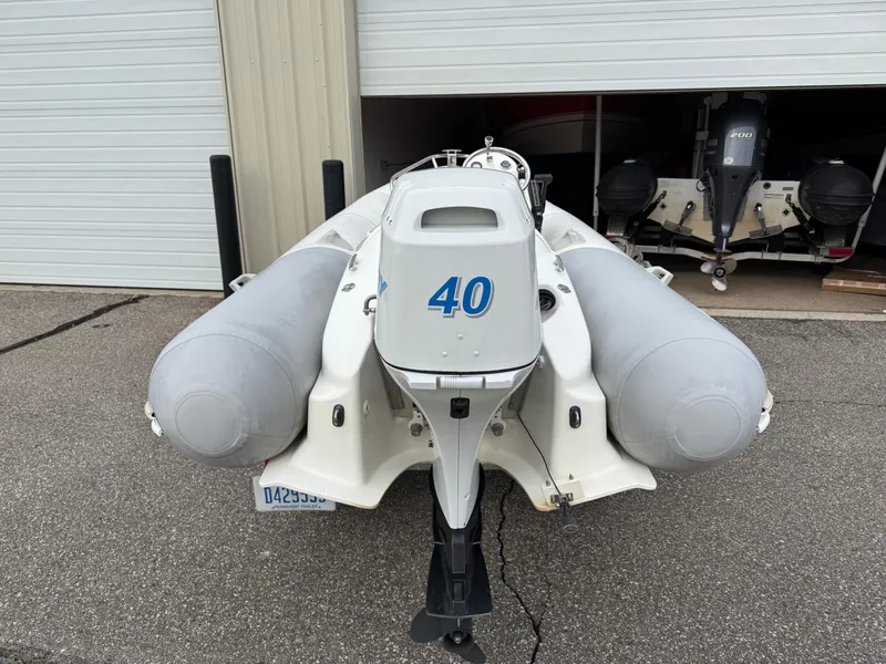 Slide: The Image of 2007 Zodiac Yachtline 380DL inflatable boat with 40 HP engine, parked near garage. - 5