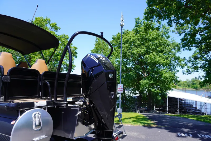 Slide: The Image of 2025 Premier 250 Sunsation RS pontoon boat with powerful outboard motor, parked near a lake. - 3