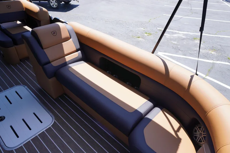 Slide: The Image of 2025 Premier 250 Sunsation RS boat interior with tan and gray seating in a parking lot. - 9
