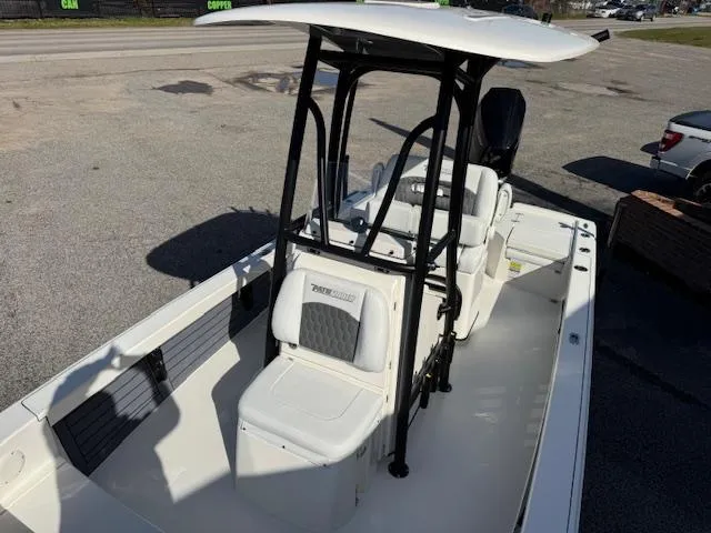 Slide: The Image of 2025 Pathfinder 2500 Hybrid boat with T-top and seating, parked on pavement. - 10