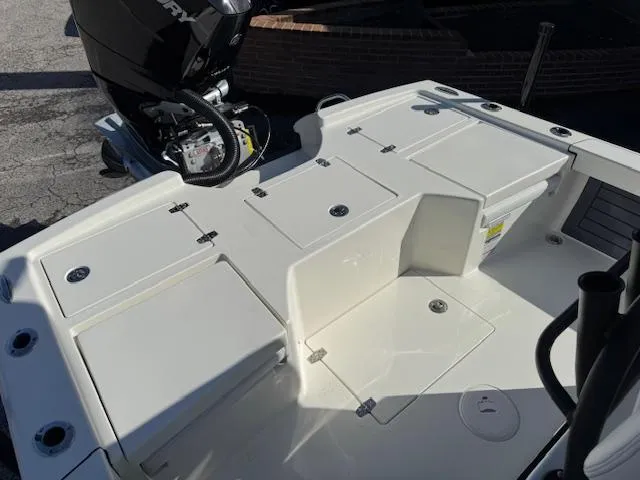 Slide: The Image of 2025 Pathfinder 2500 Hybrid boat deck with storage compartments and outboard motor. - 14