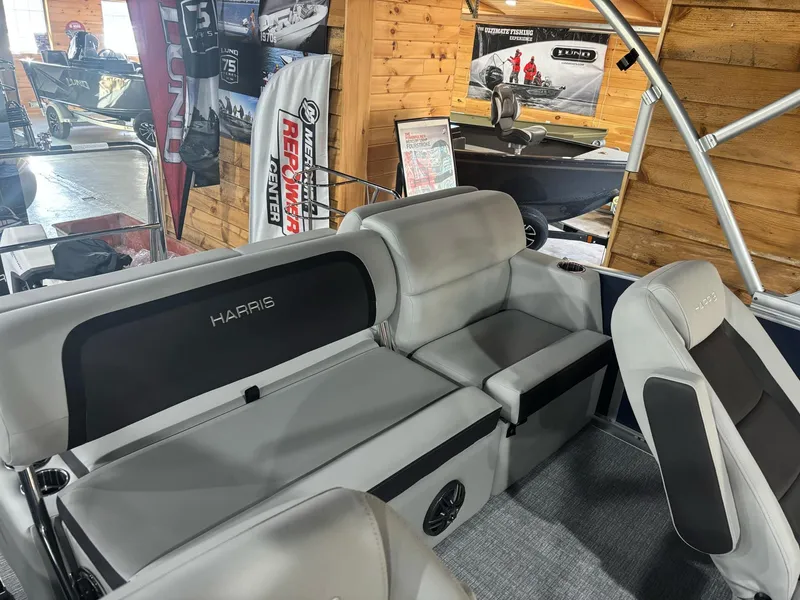 Slide: The Image of 2025 Harris Cruiser 210 interior with gray seating in a showroom. - 14
