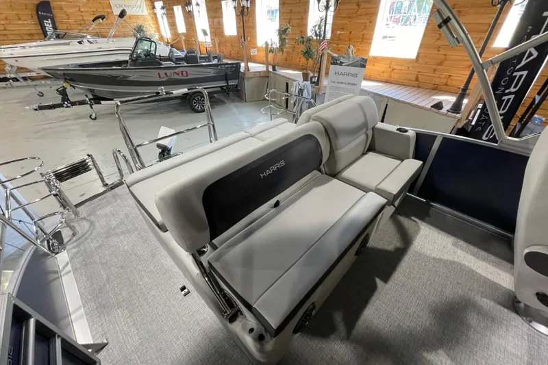 Slide: The Image of 2025 Harris Cruiser 210 boat interior with plush seating in a showroom setting. - 5