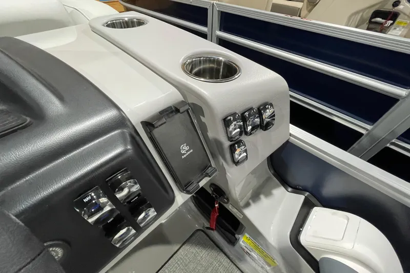 Slide: The Image of 2025 Harris Cruiser 210 boat console with cup holders and control switches. - 8
