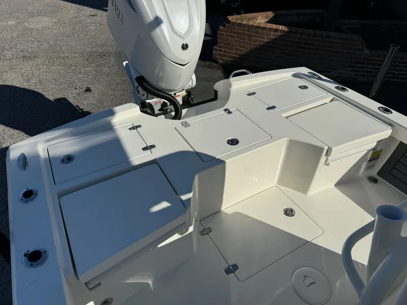 Slide: The Image of 2025 Pathfinder 2500 Hybrid boat deck with storage compartments and outboard motor. - 12