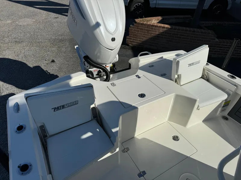 Slide: The Image of 2025 Pathfinder 2500 Hybrid boat interior with seating and motor, in a parking area. - 13