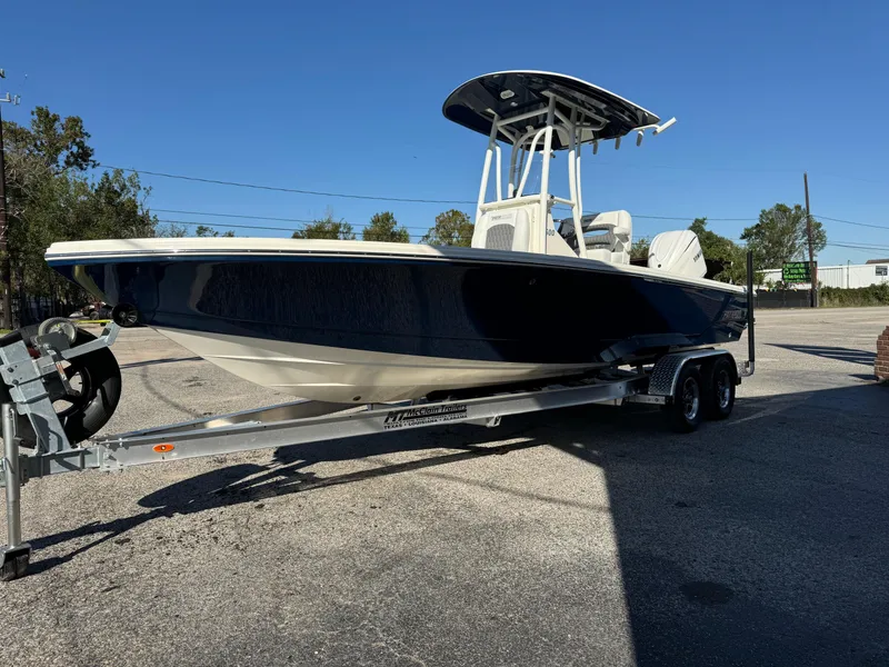 Slide: The Image of 2025 Pathfinder 2500 Hybrid boat on trailer, parked outdoors under clear blue sky. - 16