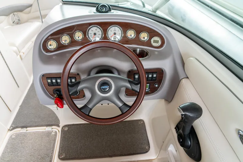 Slide: The Image of Steering wheel and dashboard of 2006 Chaparral 220 SSi boat, featuring gauges and controls. - 13