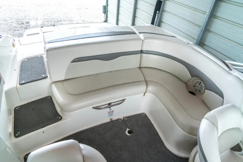Slide: The Image of 2006 Chaparral 220 SSi boat interior with white and gray seating in a garage. - 19