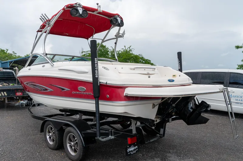 Slide: The Image of 2006 Chaparral 220 SSi boat on trailer, red and white design, parked outdoors. - 3