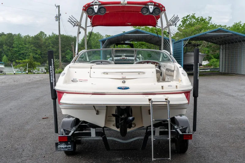 Slide: The Image of 2006 Chaparral 220 SSi boat on trailer, rear view, with red canopy and outdoor setting. - 7