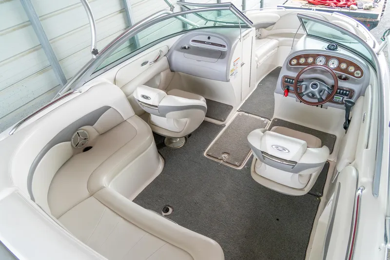 Slide: The Image of 2006 Chaparral 220 SSi boat interior with beige seating and wooden dashboard. - 9