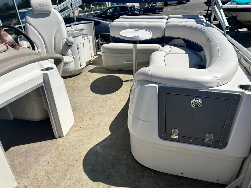 Slide: The Image of 2006 Harris 230 Royal Heritage pontoon boat interior with white seating and steering area. - 10