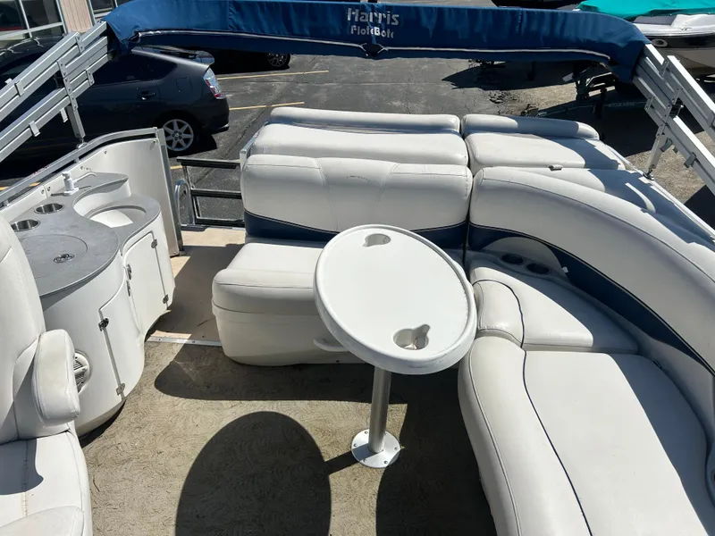 Slide: The Image of 2006 Harris 230 Royal Heritage boat interior with white seating and table. - 13