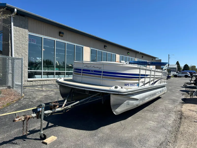 Slide: The Image of 2006 Harris 230 Royal Heritage pontoon boat parked outside a building on a sunny day. - 2