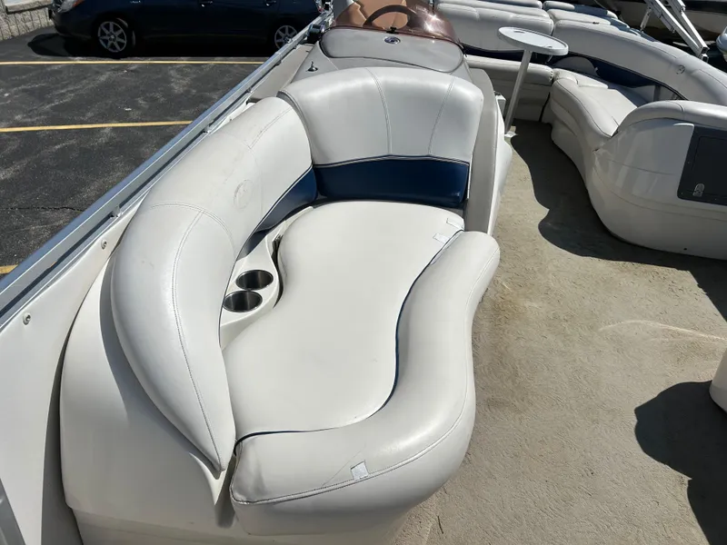Slide: The Image of 2006 Harris 230 Royal Heritage boat with white and blue seating, cup holders, and table. - 9
