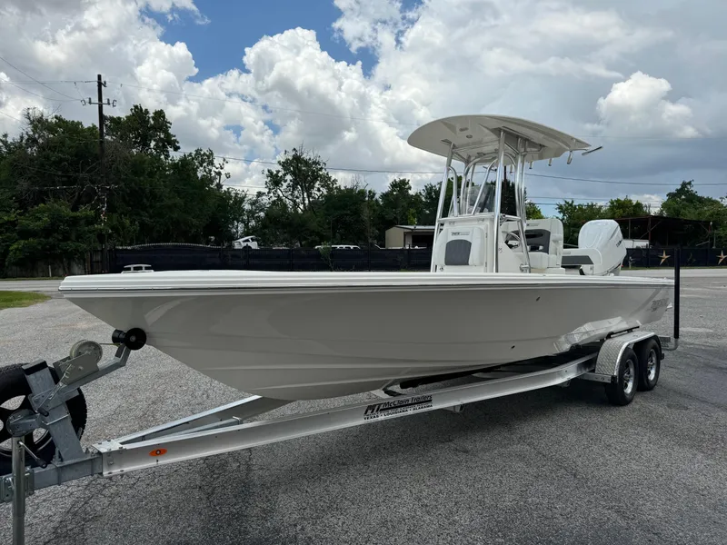 Slide: The Image of 2024 Pathfinder 2600 HPS boat on trailer, parked outdoors under cloudy sky. - 6