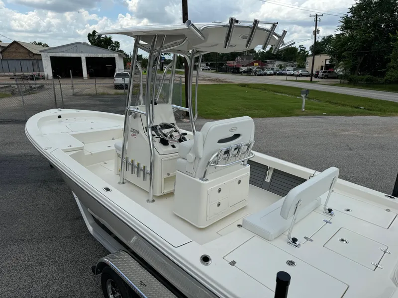 Slide: The Image of 2024 Pathfinder 2600 HPS boat with T-top and seating, parked on a trailer. - 7