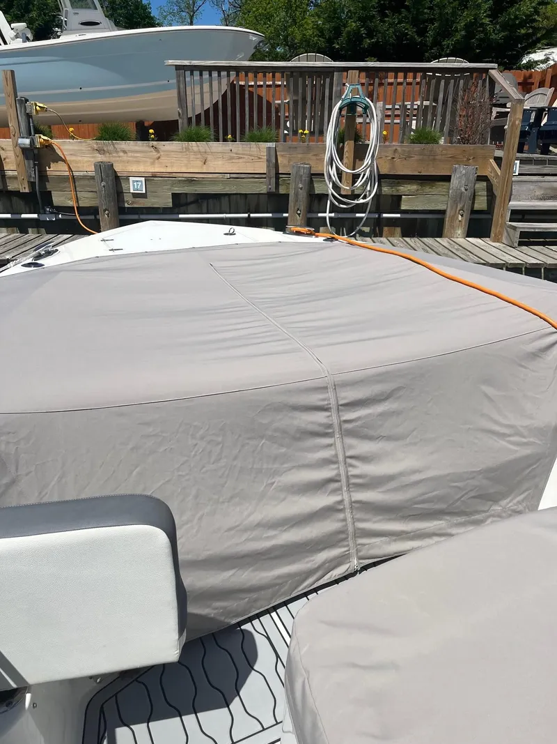 Slide: The Image of 2021 Edgewater 340CC boat with protective cover at a dock. - 10