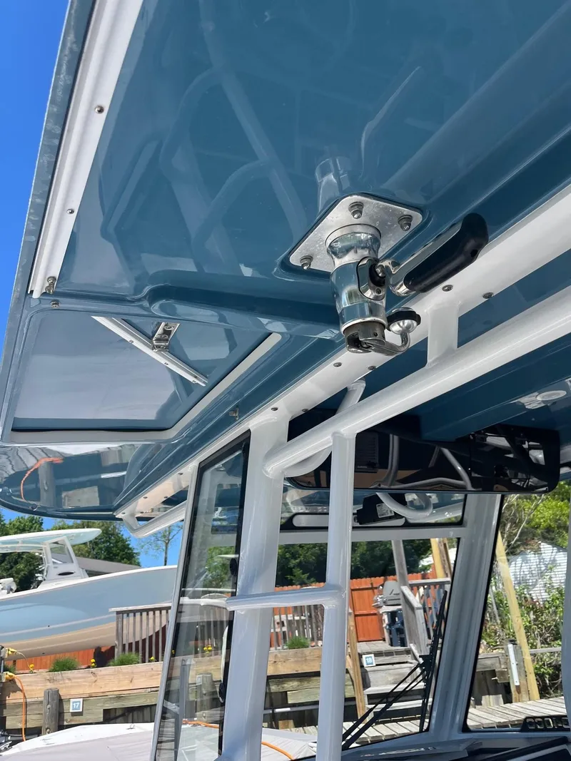 Slide: The Image of Edgewater 340CC 2021 boat with blue canopy and stainless steel fittings. - 12