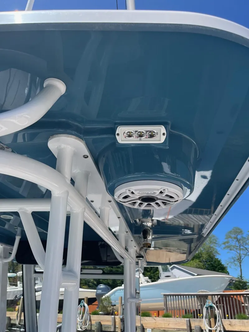 Slide: The Image of 2021 Edgewater 340CC boat with blue hull, featuring speakers and lights underneath. - 18