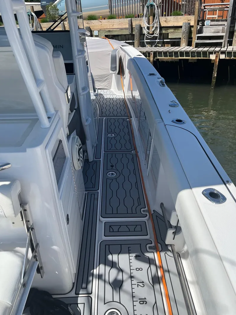 Slide: The Image of 2021 Edgewater 340CC boat deck with sleek design and modern features, docked by the water. - 19