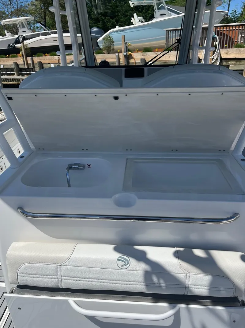 Slide: The Image of 2021 Edgewater 340CC boat with open storage compartment and sink. - 21