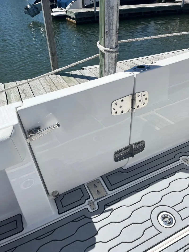 Slide: The Image of 2021 Edgewater 340CC boat with open side door, docked by the water. - 22