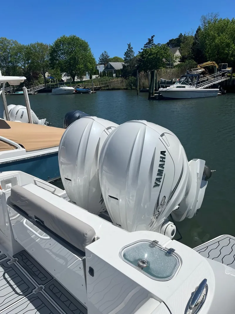 Slide: The Image of Edgewater 340CC 2021 boat with twin Yamaha outboard engines docked by a serene waterfront. - 24