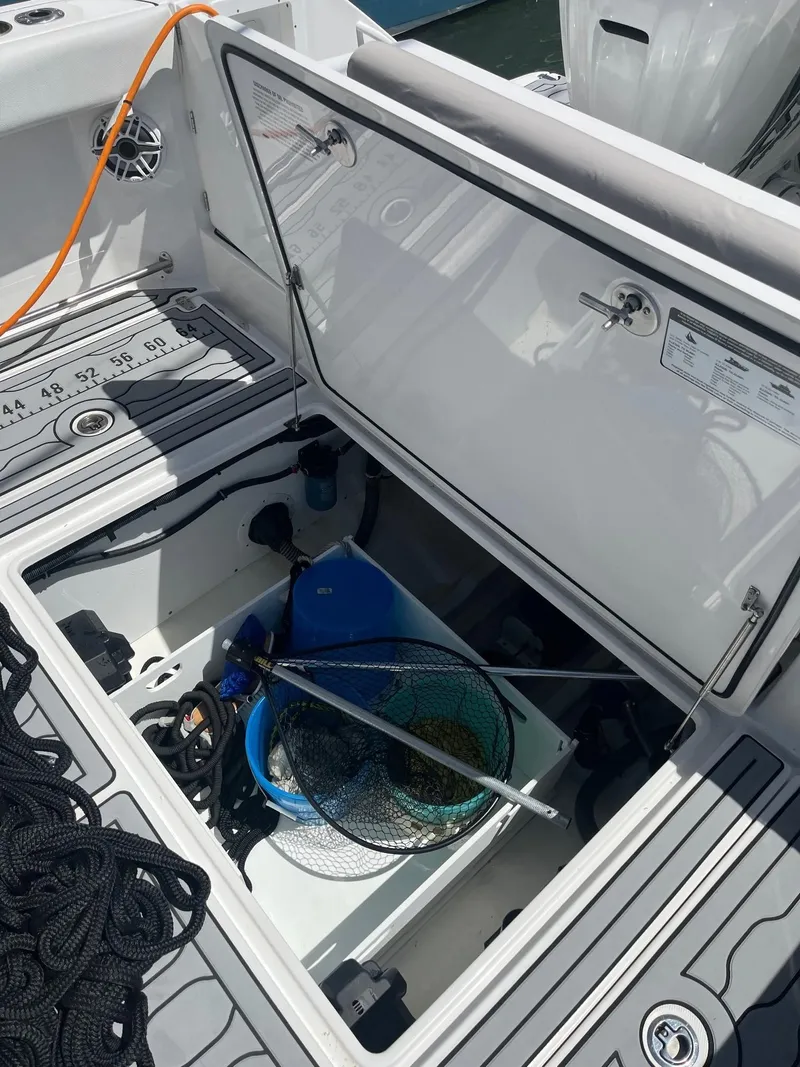 Slide: The Image of 2021 Edgewater 340CC boat storage compartment with fishing gear and net. - 4