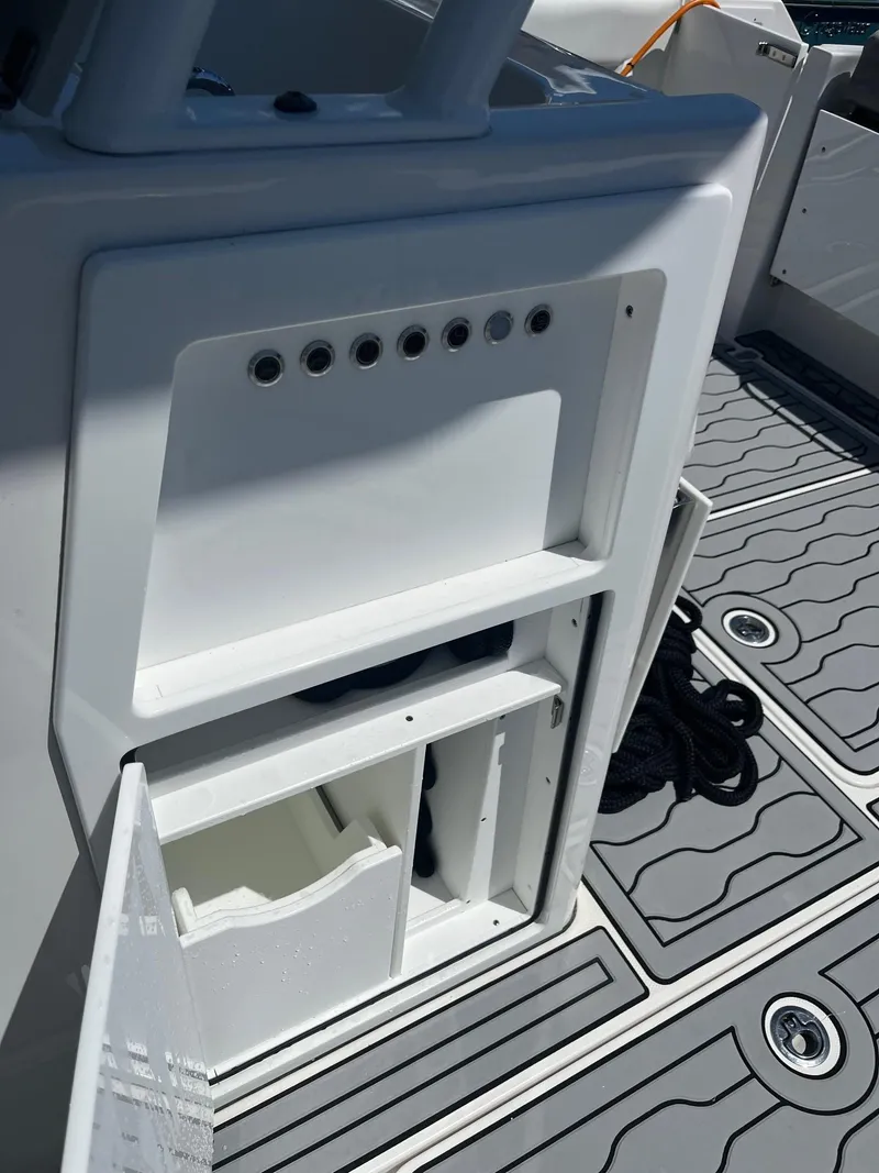 Slide: The Image of 2021 Edgewater 340CC boat interior with open storage compartment and non-slip deck. - 6