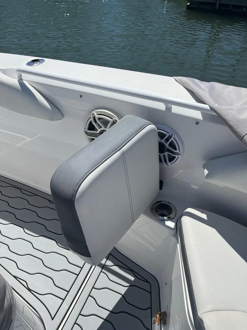 Slide: The Image of Edgewater 340CC 2021 boat interior with cushioned seating and speakers by the water. - 9