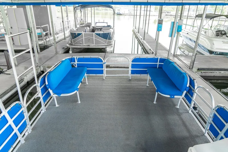 Slide: The Image of Pontoon boat with blue seating, docked in marina, part of 2000 Custom Pontoon Rental Fleet. - 18