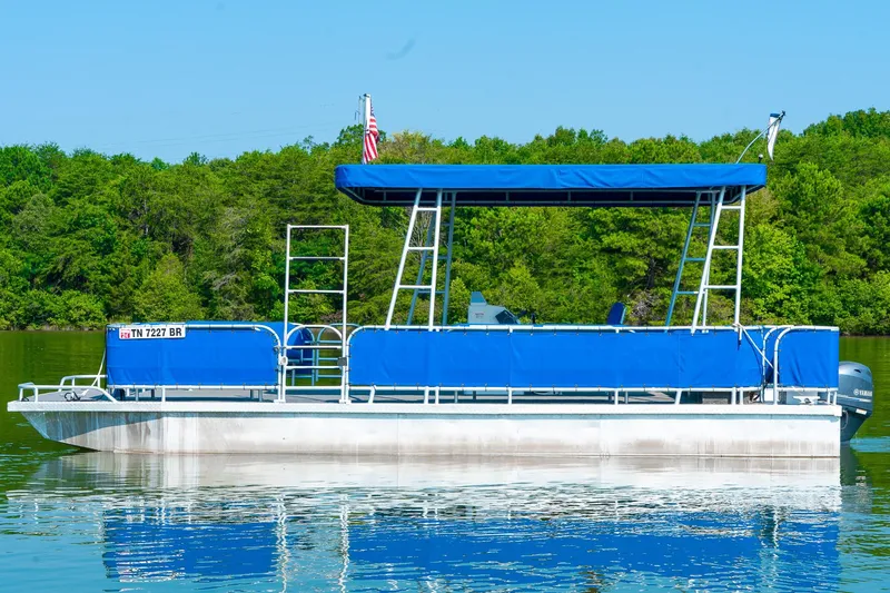 Slide: The Image of Custom 2000 pontoon rental boat with blue canopy on a serene lake. - 6
