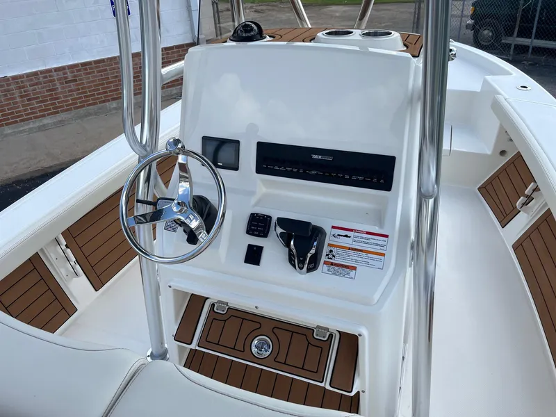 Slide: The Image of 2025 Pathfinder 2400 Open boat console with steering wheel and controls, featuring teak accents. - 9