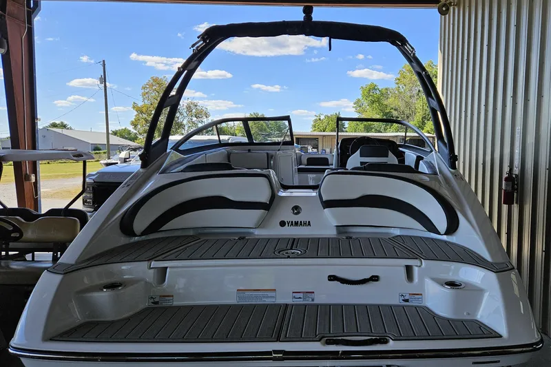 Slide: The Image of 2025 Yamaha Boats AR195, sleek design, rear view in a covered area. - 10