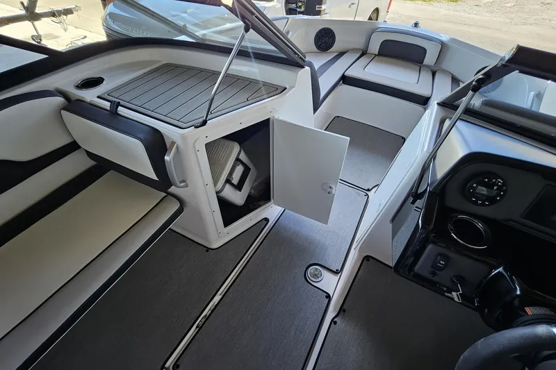 Slide: The Image of 2025 Yamaha Boats AR195 interior with open storage compartment and sleek seating. - 5