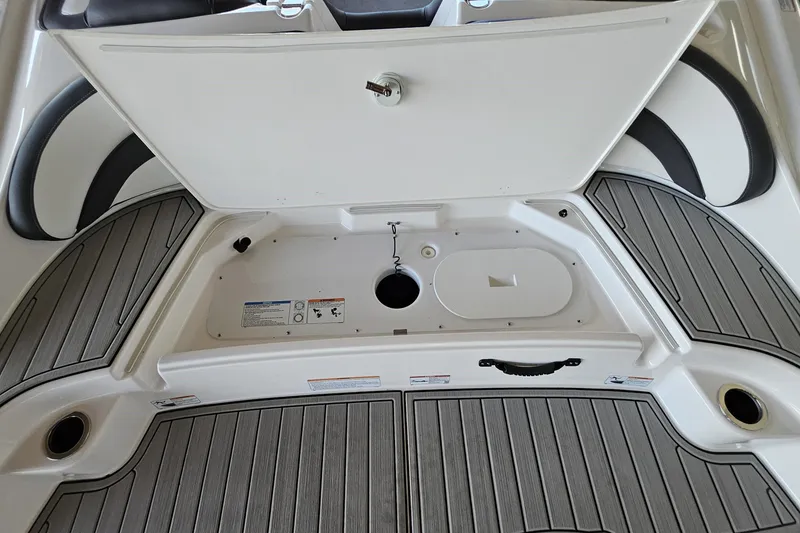 Slide: The Image of 2025 Yamaha Boats AR195 storage compartment with open hatch and sleek deck design. - 6