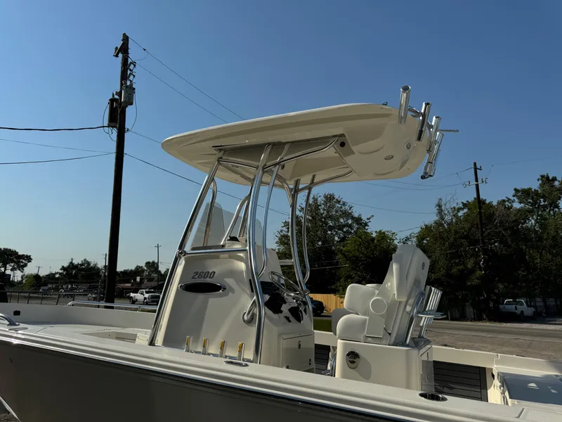 Slide: The Image of 2025 Pathfinder 2600 TRS boat with T-top and seating, parked outdoors. - 12