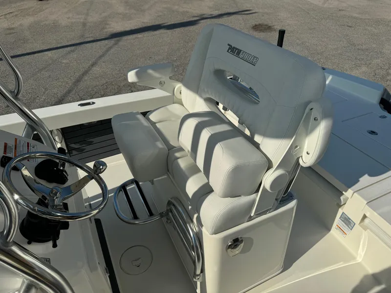 Slide: The Image of 2025 Pathfinder 2600 TRS boat interior with white cushioned seating and steering wheel. - 14