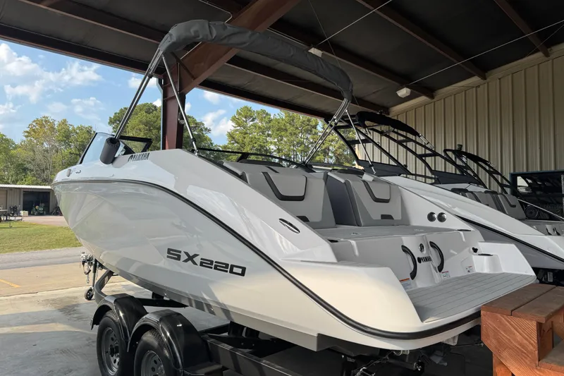 Slide: The Image of 2025 Yamaha Boats SX220 in a showroom, showcasing sleek design and modern features. - 1