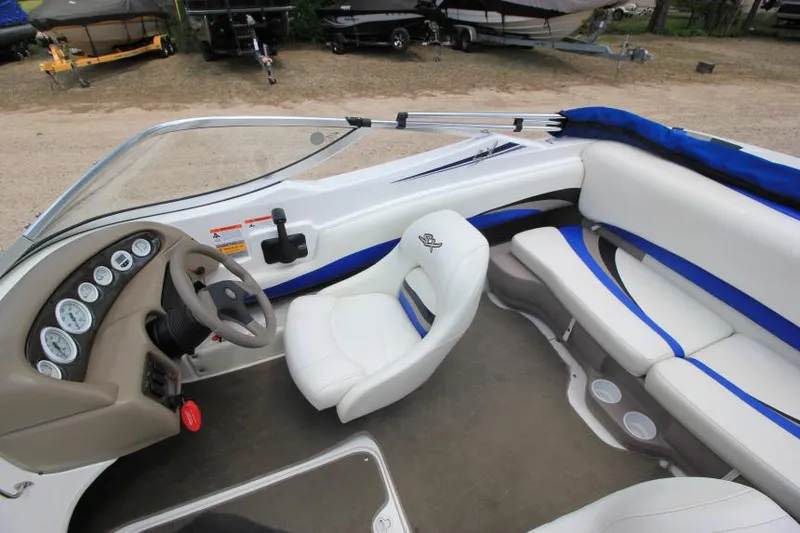 Slide: The Image of 2003 Glastron SX 175 boat interior with white and blue seating, steering wheel, and dashboard. - 10
