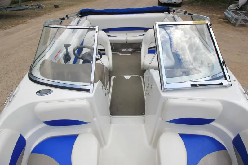 Slide: The Image of 2003 Glastron SX 175 boat interior with blue and white seating, open windshield, and steering wheel. - 19