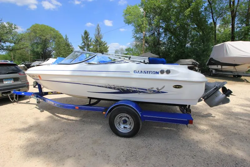 Slide: The Image of 2003 Glastron SX 175 boat on trailer, parked outdoors under clear sky. - 7