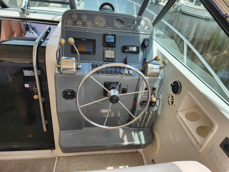 Slide: The Image of 2001 Tiara Yachts 3100 Open helm with steering wheel and control panel. - 14