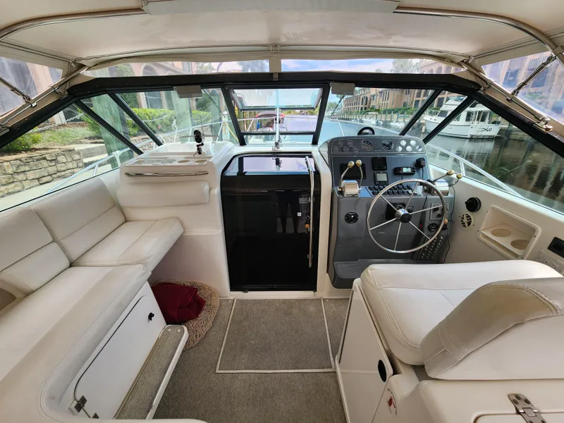 Slide: The Image of 2001 Tiara Yachts 3100 Open cockpit with steering wheel, seating, and marina view. - 15