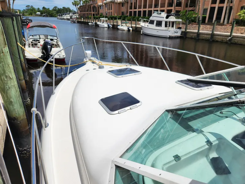 Slide: The Image of 2001 Tiara Yachts 3100 Open docked in a scenic marina setting. - 32
