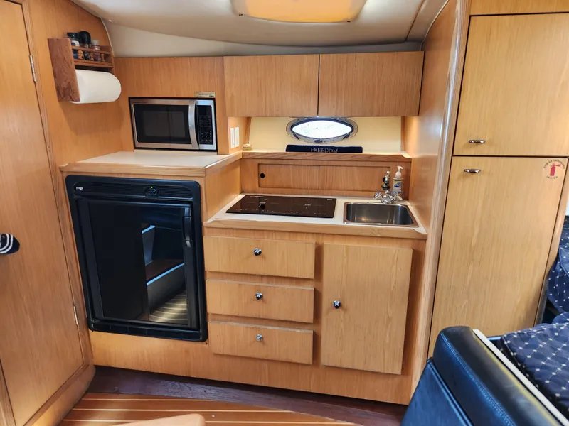 Slide: The Image of 2001 Tiara Yachts 3100 Open galley with microwave, sink, and storage cabinets. - 39